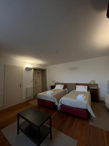 a room with two beds and a table in it at Casa da Torre in Sobrosa