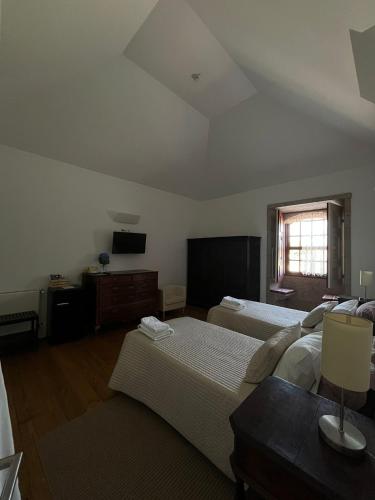 a bedroom with two beds and a table and a window at Casa da Torre in Sobrosa