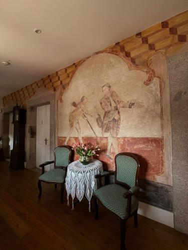 a room with a table with chairs and a painting on the wall at Casa da Torre in Sobrosa