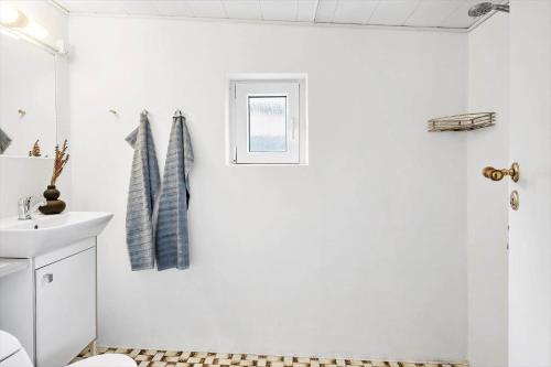a white bathroom with a sink and a mirror at 704-Thyboron-Kirkevej-6 in Thyborøn