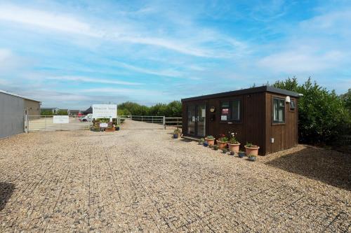 a small building with potted plants on a gravel lot at Private & Peaceful Double Ensuite Rooms in Stapleford in Stapleford