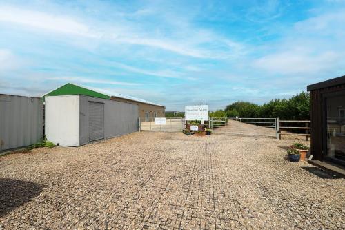 a gravel parking lot with a building and a fence at Private & Peaceful Double Ensuite Rooms in Stapleford in Stapleford