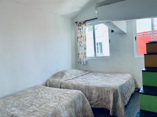 a bedroom with two beds and a window at Apartments & Rooms in Cancun next to the beach in Cancún
