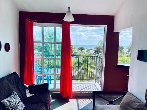 a living room with a large window with red curtains at Apartments & Rooms in Cancun next to the beach in Cancún