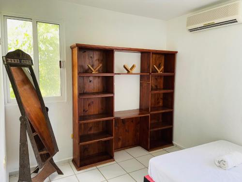a wooden book shelf in a room with a bed at Apartments & Rooms in Cancun next to the beach in Cancún