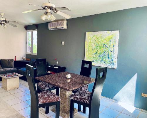 a dining room with a table and chairs and a couch at Apartments & Rooms in Cancun next to the beach in Cancún