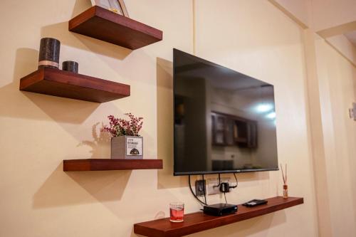 una parete con specchio e TV a parete di Maftah's Plaza a Bagamoyo