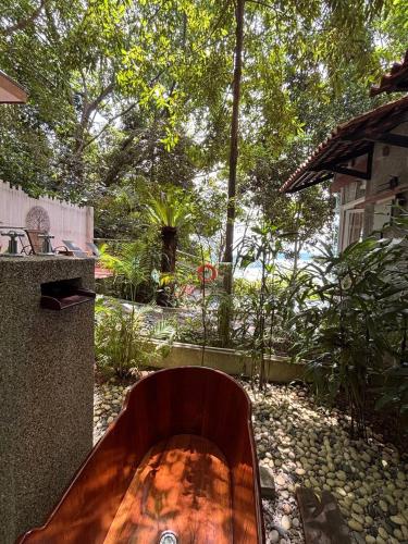 a wooden bench sitting in a garden with trees at Ambong Pool Villas - Private Pool in Pantai Cenang
