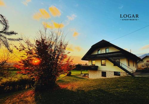 a house with a tree in front of it at LOGAR Apartments in Preddvor