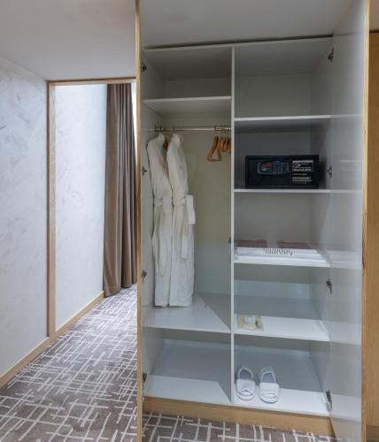 a walk in closet with a glass door at LOTTE City Hotels Tashkent Palace in Tashkent