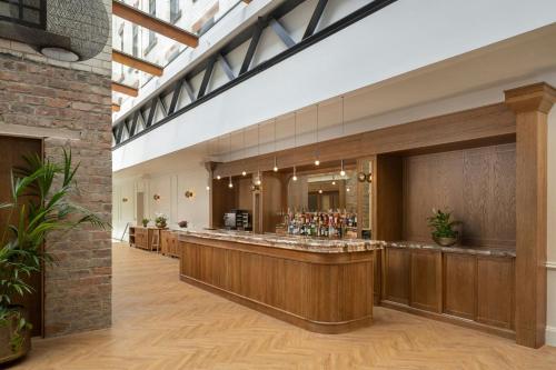 a bar in a restaurant with a brick wall at AC Hotel by Marriott Glasgow in Glasgow