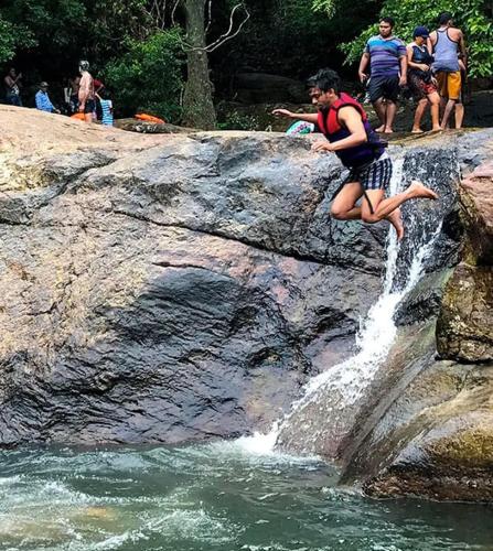 a man jumping off a rock into a waterfall at Meemure traval master in Meemure