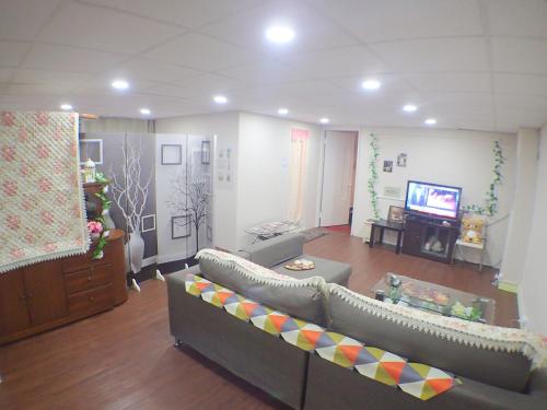a living room with a couch and a television at Ximen NIANIA in Taipei