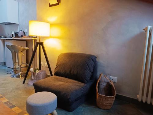 a living room with a chair and a stool at La Mansardina di Sabrina in Busca