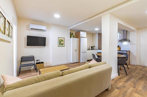 a living room with a couch and a kitchen at GMC Turistics - Paseo Marítimo Estepona in Estepona