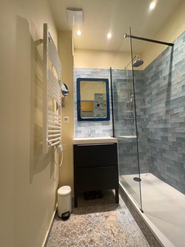 ein Badezimmer mit Waschbecken und Dusche mit Spiegel in der Unterkunft Le Barreme Arles centre in Arles
