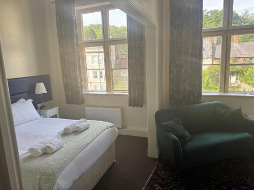 a bedroom with a bed and a chair and a window at Ruswarp Hall - Whitby in Whitby