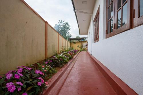 an alley with flowers on the side of a building at Carmel Crown Villa in Hatton