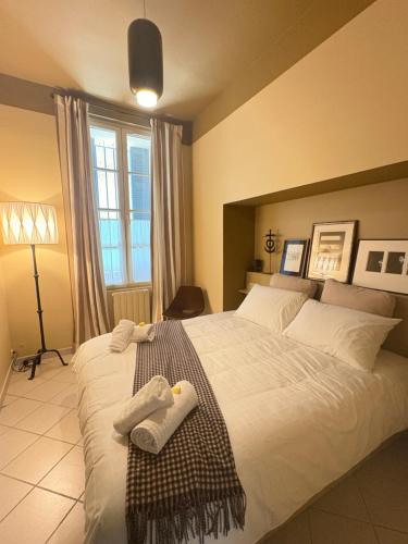 ein Schlafzimmer mit einem großen Bett, auf dem Handtücher liegen in der Unterkunft Le Barreme Arles centre in Arles
