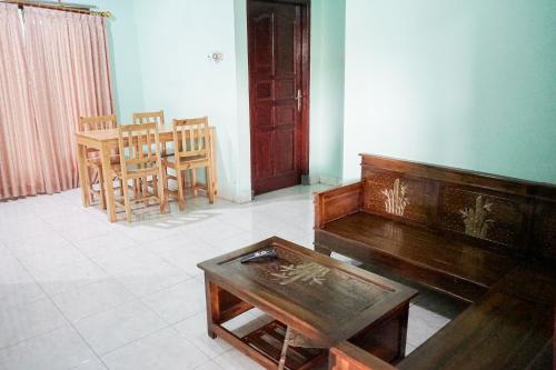 a living room with a piano and a table at Omah Seturan Homestay Jogja in Seturan