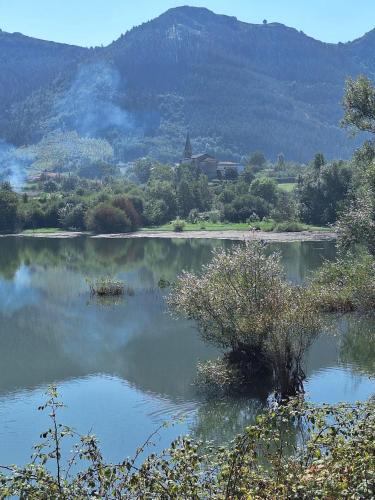 a lake with trees and mountains in the background at Casa Rural Areano in Escoriaza