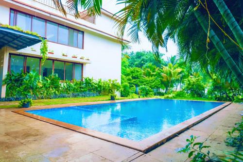 a swimming pool in front of a house at Luxury Seaside 8bhk Beach Villa Alibaug in Alibaug
