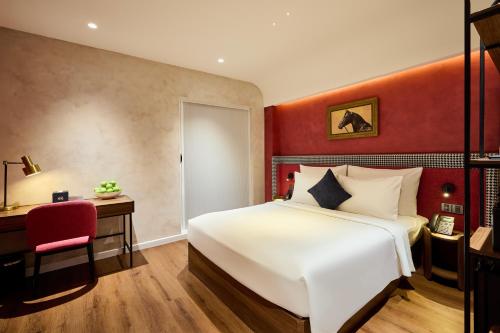 a bedroom with a large white bed and a desk at Kin Hotel Hai Ba Trung in Ho Chi Minh City
