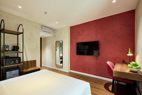 a bedroom with a bed and a red wall at Kin Hotel Hai Ba Trung in Ho Chi Minh City