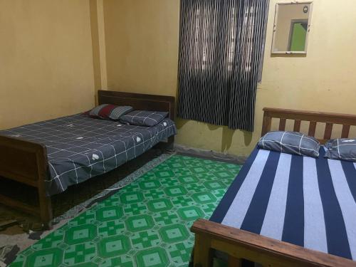 two beds in a room with green and blue at Meemure traval master in Meemure