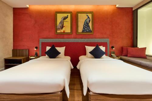 two beds in a room with red walls at Kin Hotel Hai Ba Trung in Ho Chi Minh City
