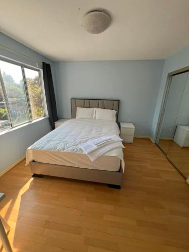 a bedroom with a bed and a large window at Luxurious and quiet room in Vancouver's West End in Vancouver