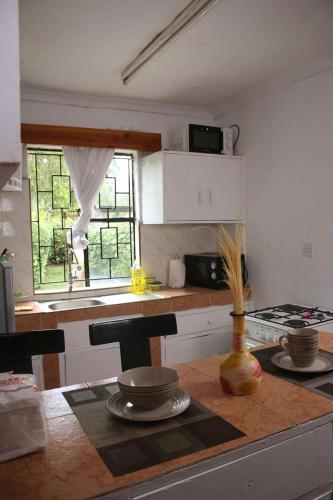 a kitchen with a table and a counter with a window at Hidden Gem 32 acre road in Nairobi