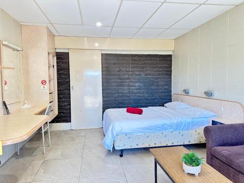 a bedroom with a bed and a couch and a table at Inland Oasis Motel in Mount Isa