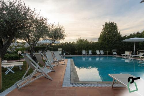 a group of chairs sitting next to a swimming pool at HOTIDAY Room Collection - Sarzana in Sarzana