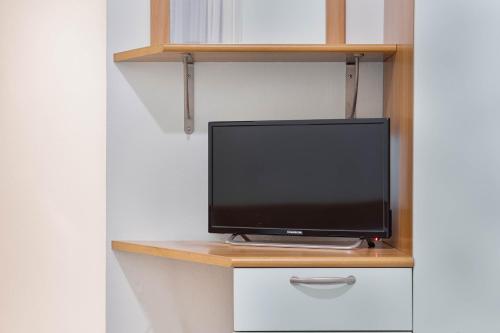 a television sitting on top of a desk at Green Village Accommodations in Colico