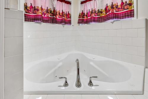 une baignoire avec deux robinets dans une salle de bain dans l'établissement Merlot Cottage - GOTL Strip - Lover's Retreat, à Geneva