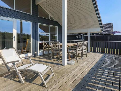 a deck with chairs and a table on a house at 6 person holiday home in Ringkøbing-By Traum in Nørby