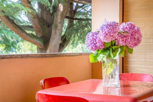 a vase of purple flowers sitting on a table at Green Village Accommodations in Colico
