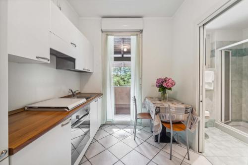 a kitchen with a table with a vase of flowers at Green Village Accommodations in Colico