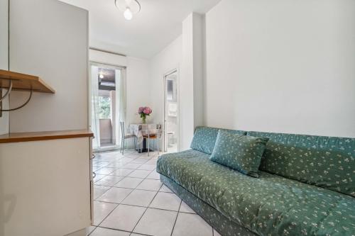 a living room with a green couch and a table at Green Village Accommodations in Colico