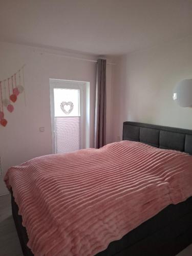 a bedroom with a large bed with a window at De Hecksche Stuuv in Kreuztal