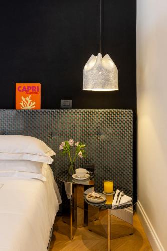 a bedroom with a bed and a table with flowers on it at Nerva Boutique Hotel in Rome