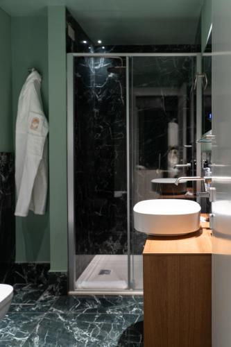 a bathroom with a sink and a glass shower at Duse Luxury Stay in Milan