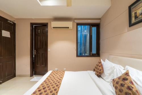 a bedroom with a white bed and a window at Cosy Grand, Chanakyapuri by The Cosy Hotels in New Delhi