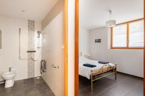 y baño con cama, ducha y lavabo. en Appartement 70m2 à 10 minutes de Lyon adapté PMR, en Saint-Genis-Laval