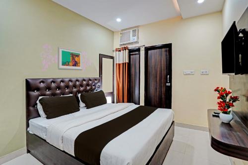a bedroom with a large bed and a desk at Hotel O MVD Inn Gomti Nagar in Lucknow
