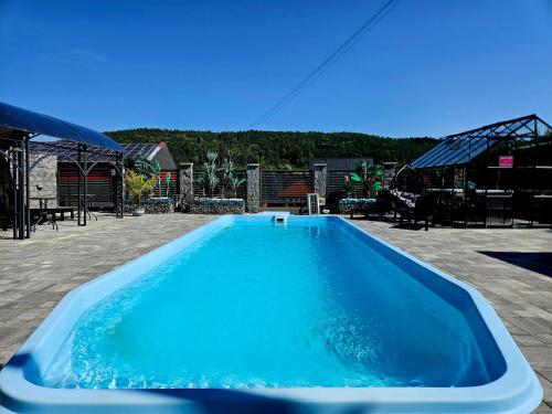 a large blue swimming pool in a yard at Apartamenty pod Gromadzyniem in Ustrzyki Dolne