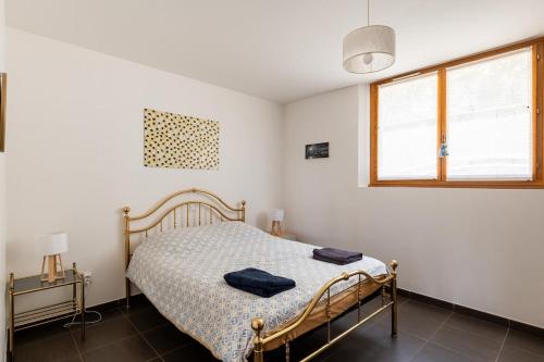 un dormitorio con una cama y una ventana en Appartement 70m2 à 10 minutes de Lyon adapté PMR, en Saint-Genis-Laval