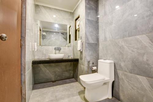 a bathroom with a toilet and a sink at Airport La Sapphire Hotel & Restaurant in New Delhi