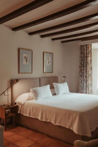 a bedroom with a large bed and a window at Rondaia, a Winery & Fincahotel-Agroturismo in Tramuntana in Esporles
